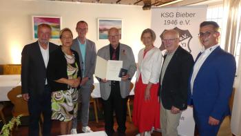 Klaus Döll mit Verdienstmedaille und Gratulanten