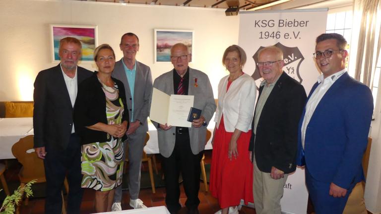 Klaus Döll mit Verdienstmedaille und Gratulanten