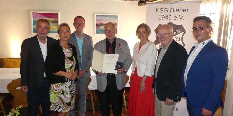Klaus Döll mit Verdienstmedaille und Gratulanten